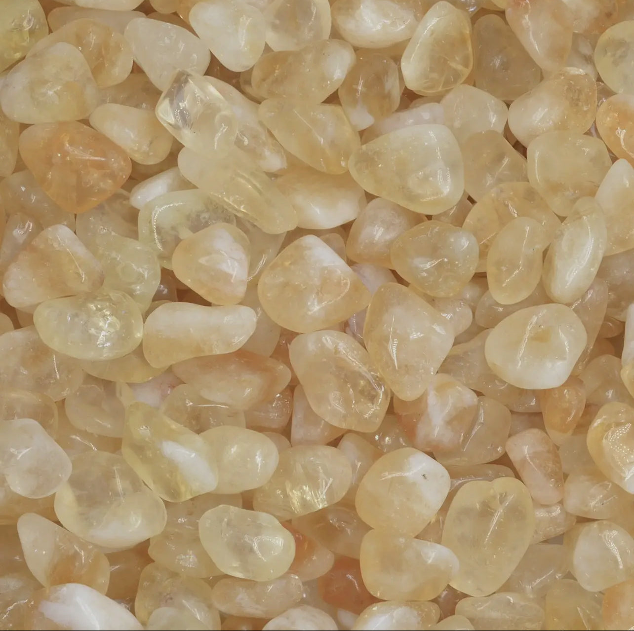 Smooth, tumbled citrine with a vibrant yellow color