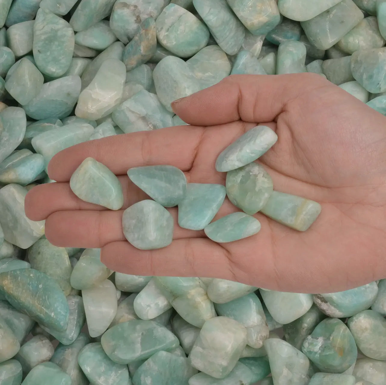 Tumbled amazonite in a crystal grid with other healing stones